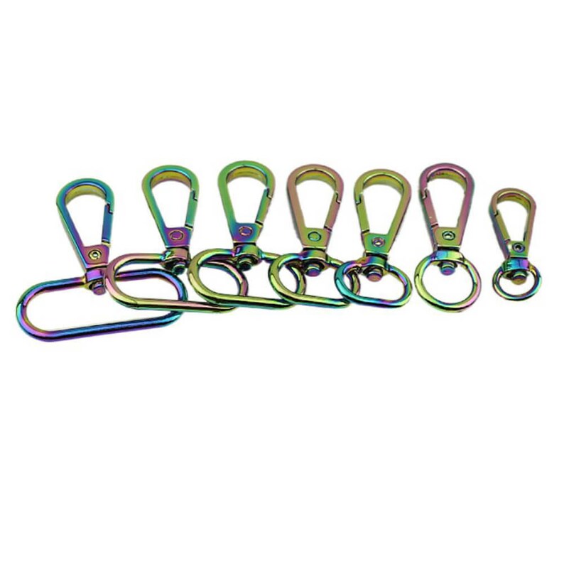 May include: A set of seven rainbow-coloured metal swivel clasps of varying sizes. The clasps are made of metal and have a shiny, iridescent finish.