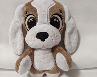 May include: A brown and white plush dog toy with large, embroidered eyes and a black nose. The dog has pink accents on its face and white paws.