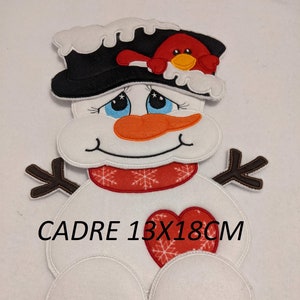 May include: A felt snowman decoration with a black hat, red scarf, and a heart on its chest. The snowman has a carrot nose, blue eyes, and a red bird on its hat. The text "CADRE 13X18CM" is printed on the image.