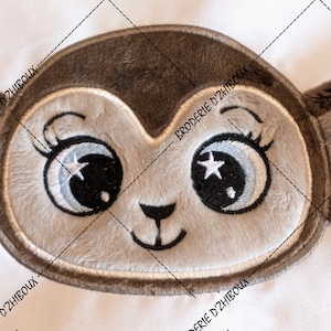 Peut inclure: Une applique en peluche de singe marron et gris avec des yeux brodés, une lune croissante et des étoiles. L'applique a un contour cousu.
