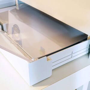 May include: White plastic drawer with a clear plastic lid. The drawer is open and the lid is partially open. The drawer has a white plastic track on the side.