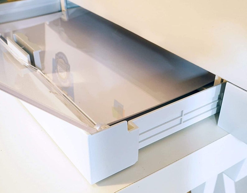May include: White plastic drawer with a clear plastic lid. The drawer is open and the lid is partially open. The drawer has a white plastic track on the side.