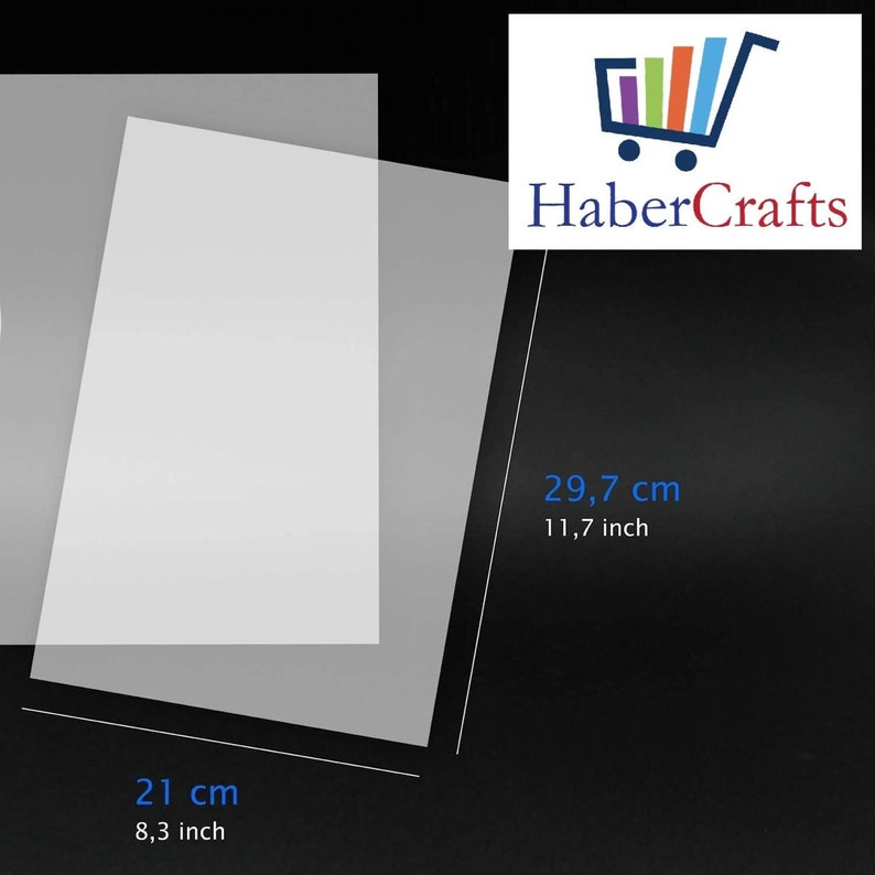 May include: A clear plastic sheet measuring 21 inches by 29.7 inches. The sheet is lying flat on a black surface.