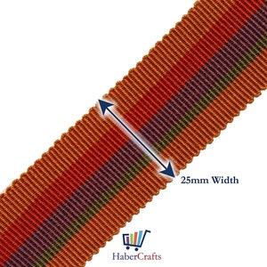 May include: A close-up of a 25mm wide striped ribbon with orange, red, purple, and green stripes. The ribbon is a woven fabric with a textured surface.