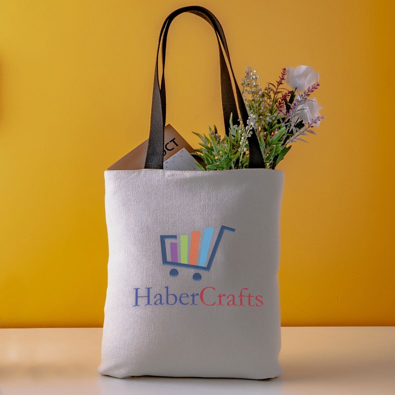 May include: White canvas tote bag with black handles. The bag has a colorful shopping cart logo and the text "HaberCrafts" printed on the front.