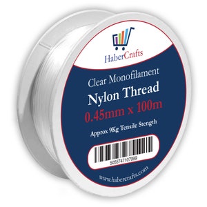 May include: A spool of clear monofilament nylon thread, 0.45mm thick and 100m long. The spool has a blue label with the text "Clear Monofilament Nylon Thread 0.45mm x 100m" and "Approx 9Kg Tensile Stength". The label also includes a barcode and the website address "www.habercrafts.com".