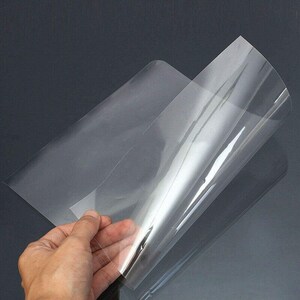 May include: A clear plastic sheet, folded in half, with a smooth, glossy surface. The sheet is translucent and appears to be very thin.