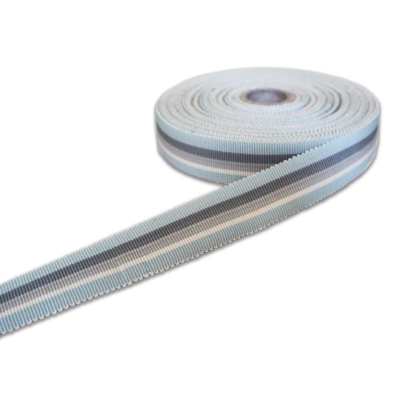 May include: A roll of light blue ribbon with white and grey stripes. The ribbon is 1 inch wide and has a scalloped edge.