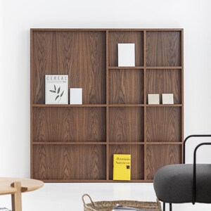 May include: A wooden bookshelf with nine compartments, featuring a magazine titled "Cereal" and a yellow book titled "Petronio Satyricon".