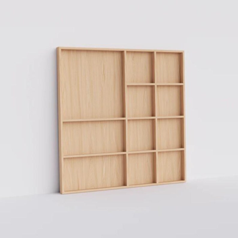 May include: A light wood wall shelf with 12 square compartments. The shelf is made of natural wood and has a simple, modern design.