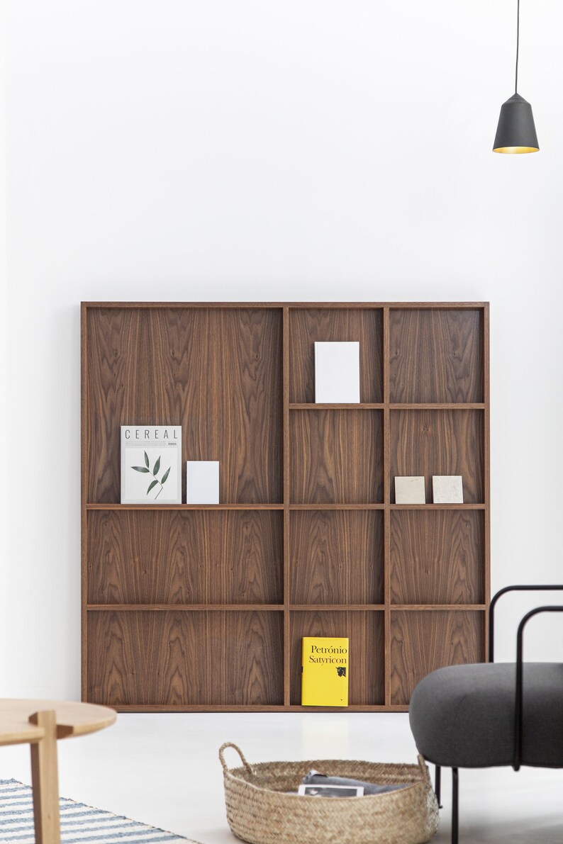 May include: A wooden bookshelf with nine compartments, featuring a magazine titled "Cereal" and a yellow book titled "Petronio Satyricon".
