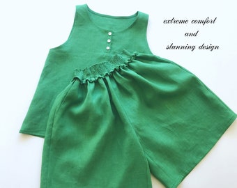 Pode incluir: Um conjunto de linho verde de duas peças com uma blusa sem mangas e calças largas. A blusa tem um fecho de botão e as calças têm uma cintura elástica. "Conforto extremo e design deslumbrante" está escrito no canto superior direito da imagem.