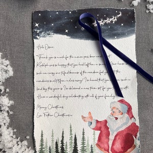 May include: A watercolour illustration of Father Christmas with a red suit and white beard, standing in a snowy forest with a blue ribbon tied around his hand. The text reads "Hello Oscar, Thank you so much for the mince pies, beer and... Rudolph was so happy that you had left him a snack... our house was such an easy one to find because of the reindeer food you... the reindeer smelt it from miles away! I've heard that you... on such a kind buy this year so I've delivered a new train set for you to play with... Have a wonderful day celebrating with all of your family. Merry Christmas Love Father Christmas x"