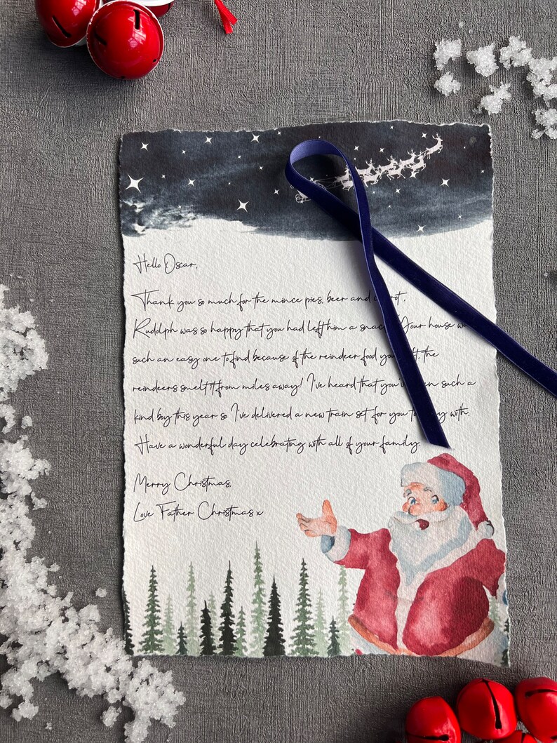 May include: A watercolour illustration of Father Christmas with a red suit and white beard, standing in a snowy forest with a blue ribbon tied around his hand. The text reads "Hello Oscar, Thank you so much for the mince pies, beer and... Rudolph was so happy that you had left him a snack... our house was such an easy one to find because of the reindeer food you... the reindeer smelt it from miles away! I've heard that you... on such a kind buy this year so I've delivered a new train set for you to play with... Have a wonderful day celebrating with all of your family. Merry Christmas Love Father Christmas x"