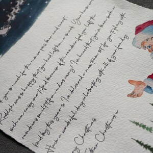May include: A handwritten letter from Santa Claus with a watercolour illustration of Santa Claus in a red suit and a white beard. The letter is written on a white background with a blue watercolour wash at the top. The letter says "Hello Oscar. Thank you so much for the mince pies beer and carrot. Rudolph was so happy that you had left them a snack. Your hagwats reindeer smelt it from miles away! I've heard that you've been such a kind boy this year so I've delivered a new train set for you to play with. Have a wonderful day celebrating with all of your family. Merry Christmas.  Other Christmas."