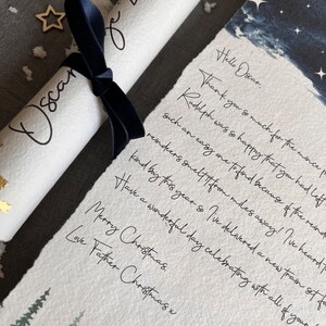 May include: A handwritten note on a white scroll with a blue ribbon, reading "Hello Oscar. Thank you so much for the mince pie. Rudolph was so happy that you had left such an easy one to find because of the reindeer. Reindeer smelt it from miles away! I've heard of a kind boy this year so I've delivered a new train set for you. Have a wonderful day celebrating with all of your family. Merry Christmas. Love Father Christmas x"