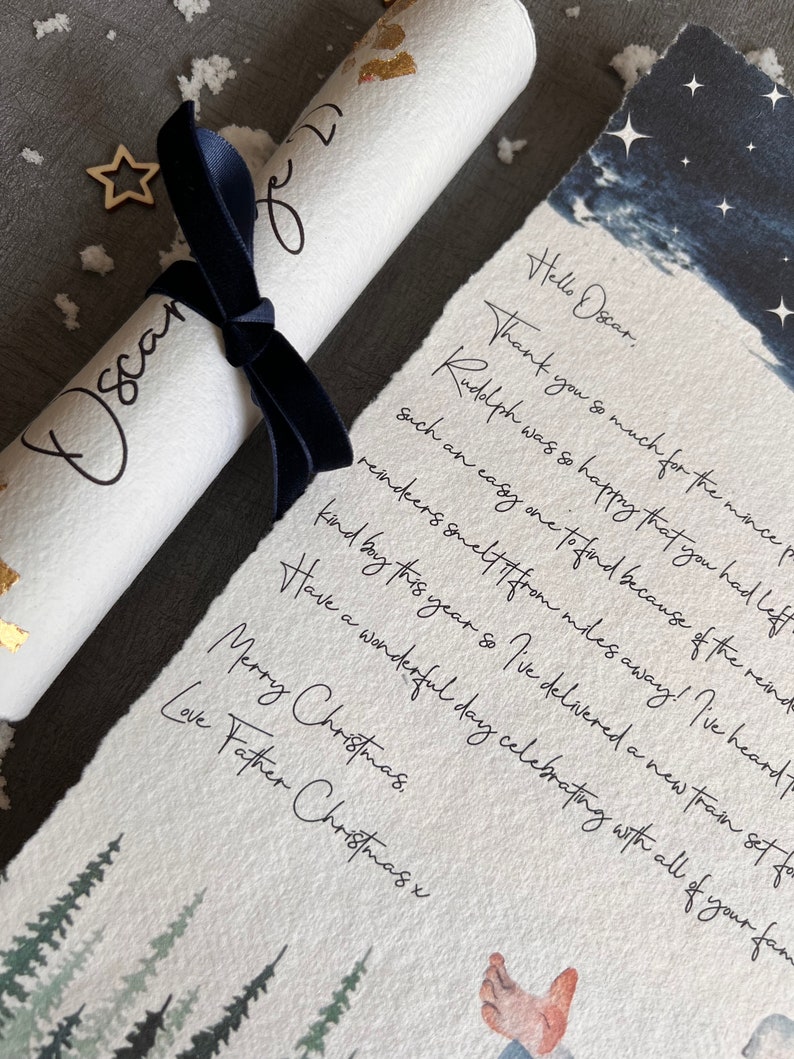 May include: A handwritten note on a white scroll with a blue ribbon, reading "Hello Oscar. Thank you so much for the mince pie. Rudolph was so happy that you had left such an easy one to find because of the reindeer. Reindeer smelt it from miles away! I've heard of a kind boy this year so I've delivered a new train set for you. Have a wonderful day celebrating with all of your family. Merry Christmas. Love Father Christmas x"