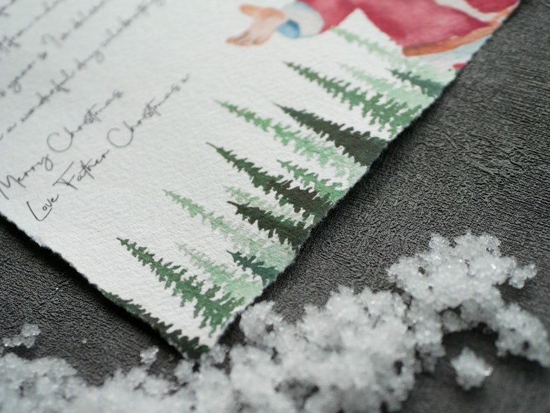May include: A watercolour Christmas card with a handwritten message that reads "Merry Christmas Love Father Christmas". The card features a snowy forest scene with green pine trees.