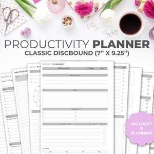 May include: A set of nine productivity planners in a white and gray color scheme. The planners are designed for daily, monthly, and project planning. The planners are 7 inches by 9.25 inches and are bound with a disc system.