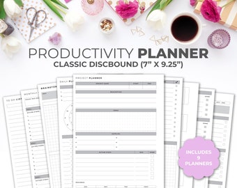 May include: A set of nine productivity planners in a white and gray color scheme. The planners are designed for daily, monthly, and project planning. The planners are 7 inches by 9.25 inches and are bound with a disc system.