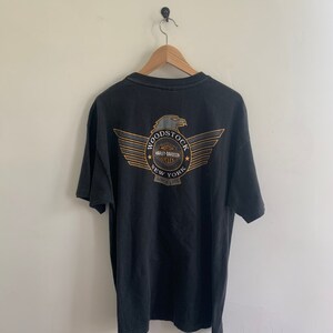 May include: Black t-shirt with a graphic of a Harley Davidson eagle and the text "Woodstock New York Since 1978"