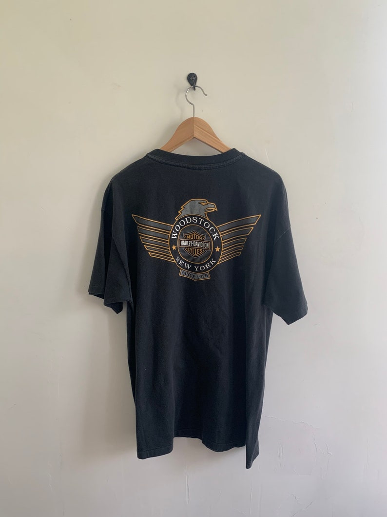 May include: Black t-shirt with a graphic of a Harley Davidson eagle and the text "Woodstock New York Since 1978"