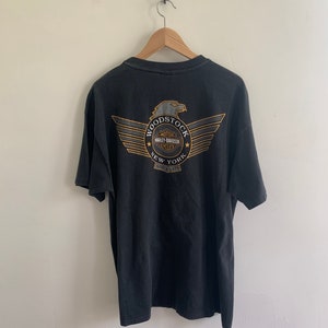 May include: Black t-shirt with a graphic of a winged eagle and the text "Woodstock Motor Harley Davidson Cycles New York Since 1975"
