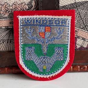 Könnte beinhalten: Rustikales Holzschild mit dem Text "Welcome to our home" in weißer Schrift. Das Schild hat eine Used-Optik und ein schlichtes, einladendes Design, ideal für die Dekoration der Haustür.