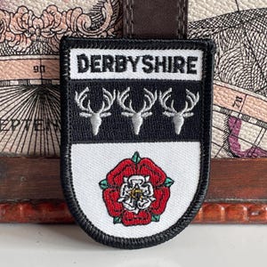 May include: A set of three ceramic mugs with a speckled, matte finish. The mugs are in shades of cream, light gray, and dark gray. Each mug has a simple, minimalist design, perfect for coffee or tea.