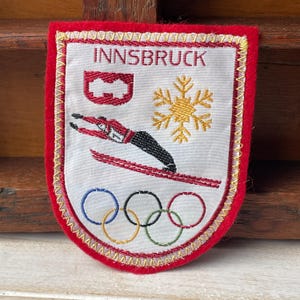 Könnte beinhalten: Eine weiße Keramik-Tasse mit schwarzem Henkel und dem Text "But First, Coffee" in schwarzer, fetter Schrift. Die Tasse steht auf einer Holzoberfläche. Die Tasse ist 10 cm hoch.