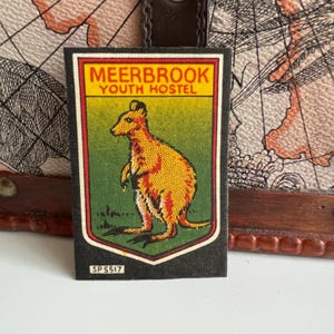 Op de afbeelding: Een zwart en groene patch met een gele kangoeroe en de tekst "Meerbrook Youth Hostel" en "SP 5517".