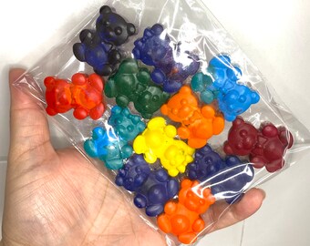 May include: A clear plastic bag filled with colorful bear-shaped crayons. The crayons are arranged in a rainbow pattern, with red, orange, yellow, green, blue, and purple crayons.
