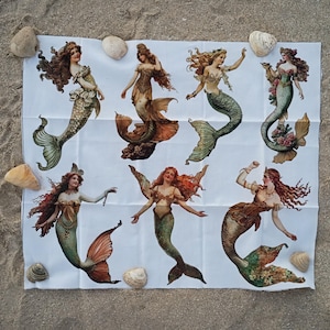 Puede incluir: Un panel de tela blanca con siete ilustraciones distintas de sirenas con cabello largo y fluido y colas detalladas en tonos verde, dorado y cobre. Cada sirena está representada en una pose diferente, mostrando ropa y escamas intrincadas.