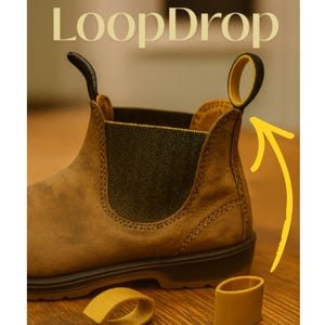 Może przedstawiać: Brązowy zamszowy but z czarnym i żółtym uchwytem. Obraz zawiera tekst "LoopDrop" i "Did anyone else miss their loop this morning?" ze strzałką wskazującą na uchwyt i dwoma żółtymi pętlami.