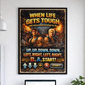 May include: A framed poster with the text "WHEN LIFE GETS TOUGH" and instructions for a video game. The poster features two muscular men and a retro gaming theme. The poster is hanging above a desk with a computer.