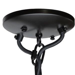 May include: A black ceiling rose with a circular design. It features three screws and two black fabric-covered wires. A black chain is suspended from the centre of the rose.