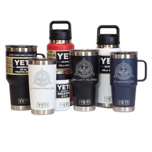 May include: A collection of Yeti Rambler drinkware in various sizes and colors, including black, white, red, and navy. Some tumblers feature custom engravings with medical symbols and names. The collection includes a 30 oz, 26 oz, and 36 oz Rambler.