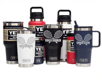 May include: A collection of YETI Rambler tumblers, bottles, and can insulators in various colours including black, white, red, and navy blue. Several items feature custom laser-engraved tennis racket graphics and names like Nathaniel, Coach Koehler, and Coach Steve.