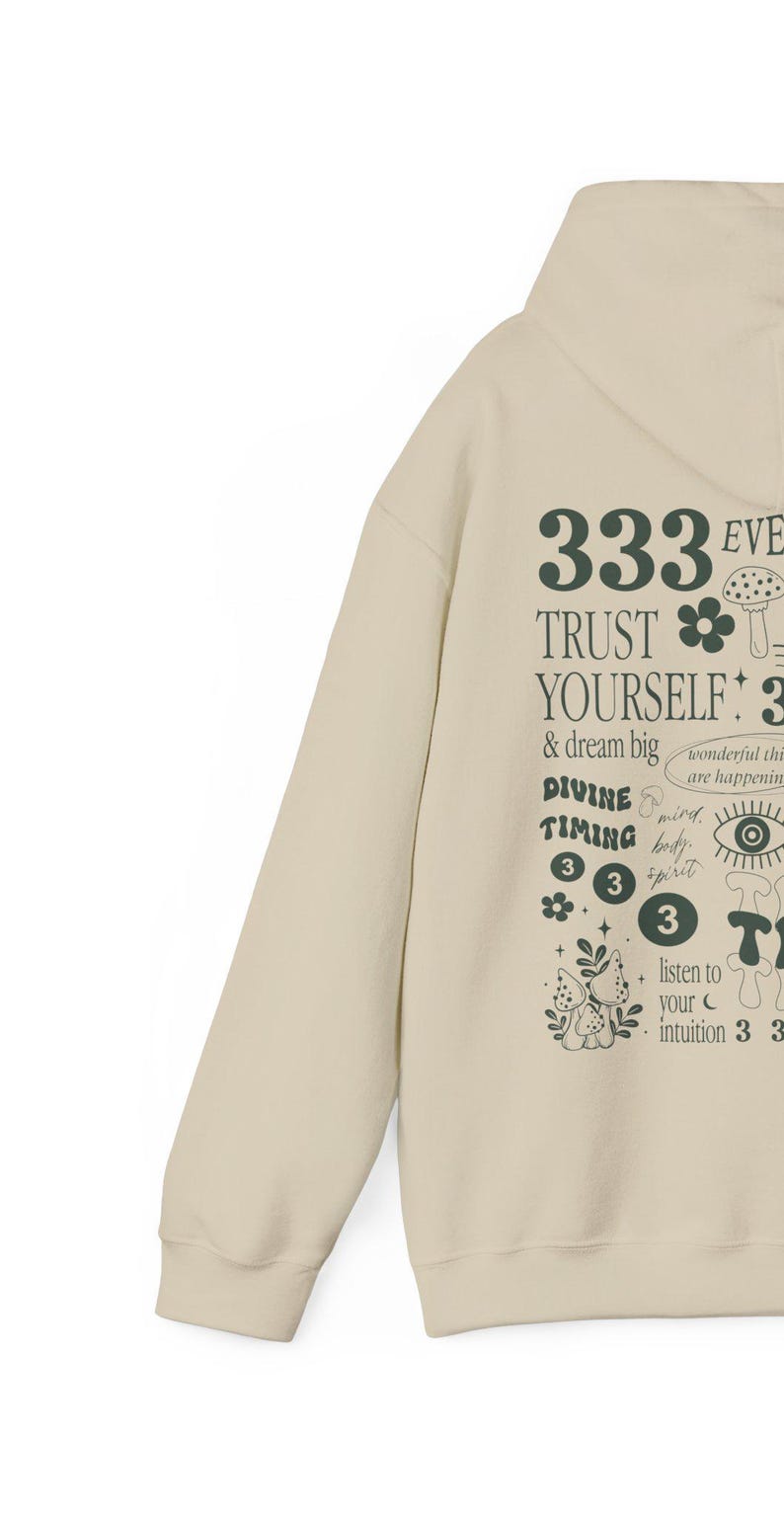 May include: A beige hoodie with a green graphic print featuring the text "333 Trust Yourself 3 & dream big", "Divine Timing 333", and "listen to your intuition 333".