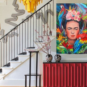 Pu&ograve; includere: Un mobile rosso con scanalature verticali, un piano nero e due vasi a pois neri e bianchi in cima. Un tappeto a strisce bianche e nere &egrave; sul pavimento davanti al mobile. Una sedia in metallo nero &egrave; a sinistra del mobile. Una scala con una ringhiera in metallo nero &egrave; sullo sfondo. Un lampadario giallo pende dal soffitto. Un dipinto di Frida Kahlo con pappagalli e fiori &egrave; sul muro dietro il mobile.