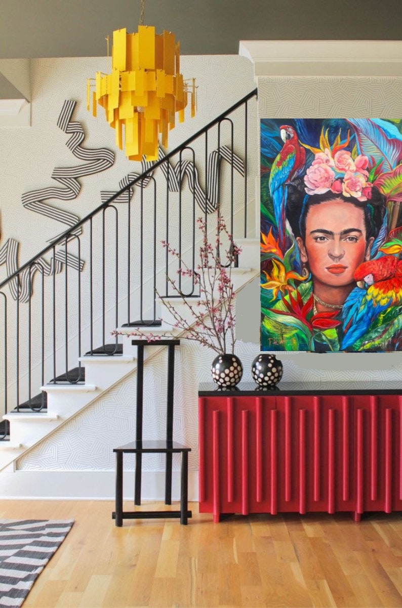 Pu&ograve; includere: Un mobile rosso con scanalature verticali, un piano nero e due vasi a pois neri e bianchi in cima. Un tappeto a strisce bianche e nere &egrave; sul pavimento davanti al mobile. Una sedia in metallo nero &egrave; a sinistra del mobile. Una scala con una ringhiera in metallo nero &egrave; sullo sfondo. Un lampadario giallo pende dal soffitto. Un dipinto di Frida Kahlo con pappagalli e fiori &egrave; sul muro dietro il mobile.