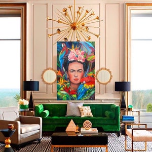 Pu&ograve; includere: Un divano in velluto verde con bordi dorati si trova in un soggiorno con un tappeto a motivi bianco e nero. Un dipinto di Frida Kahlo con pappagalli e fiori &egrave; appeso al muro sopra il divano. La stanza &egrave; decorata con accenti dorati e un grande lampadario dorato.