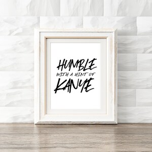 Może przedstawiać: Biała oprawa z nadrukiem czarnego tekstu "Humble with a hint of Kanye".