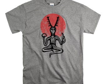 May include: A grey t-shirt featuring a black and white illustration of a horned figure sitting in a meditative pose. The figure is surrounded by a red circle with a distressed texture.