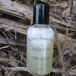 May include: A clear plastic bottle with a black cap and a white label that reads "B Berry Farms & Co. Shampoo Off Limits 2 oz".