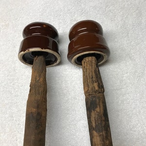 Antique porcelain insulators with wooden mounting peg.
