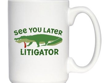 May include: White ceramic coffee mug with a green alligator wearing a red tie and the text "See you later Litigator".