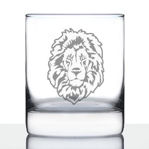 May include: A clear glass tumbler with an etched design of a lion's face. The lion's face is in the center of the glass and is facing forward.