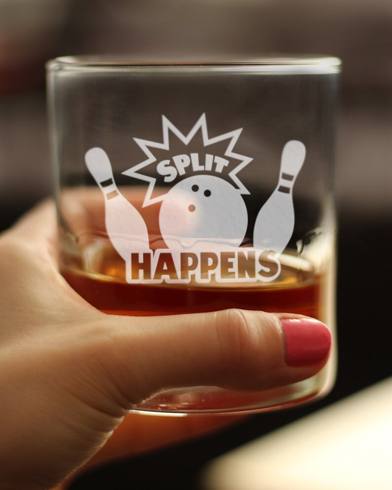 Pode incluir: Um copo transparente com um desenho gravado em branco de pinos de boliche e uma bola de boliche com o texto "SPLIT HAPPENS". O copo est&aacute; cheio de um l&iacute;quido castanho.