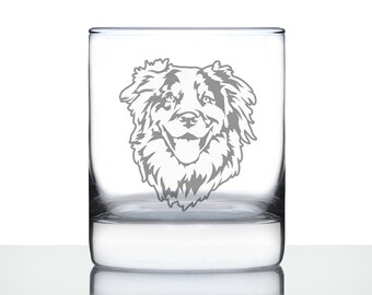 Könnte beinhalten: Ein durchsichtiger Glasbecher mit einem geätzten Design eines Australian Shepherd-Hunde-Kopfes. Der Hund schaut direkt auf den Betrachter, mit leicht geöffnetem Maul, als würde er lächeln.